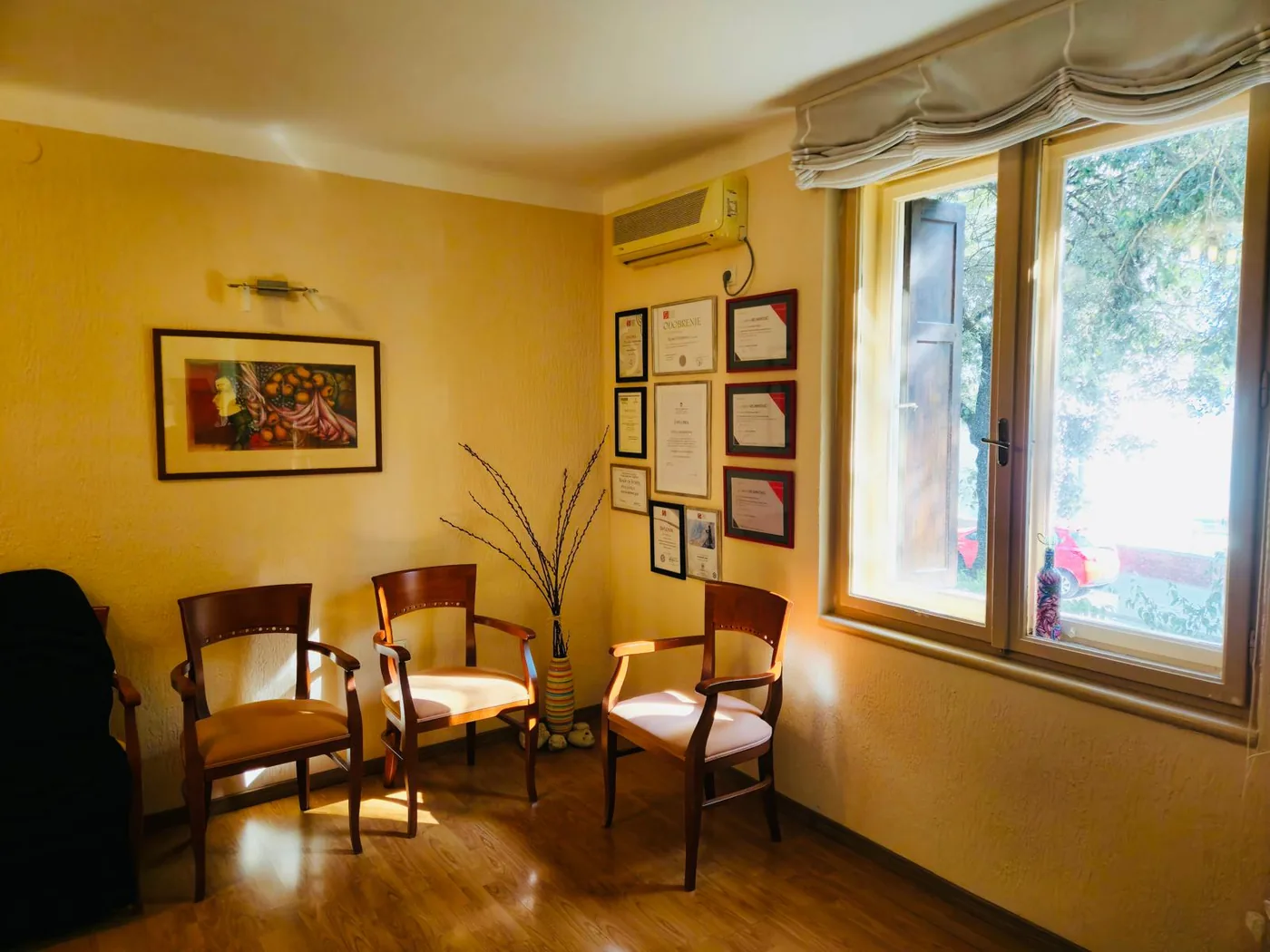 Čekaonica ordinacije s drvenim stolcima i prirodnim svjetlom kroz prozor